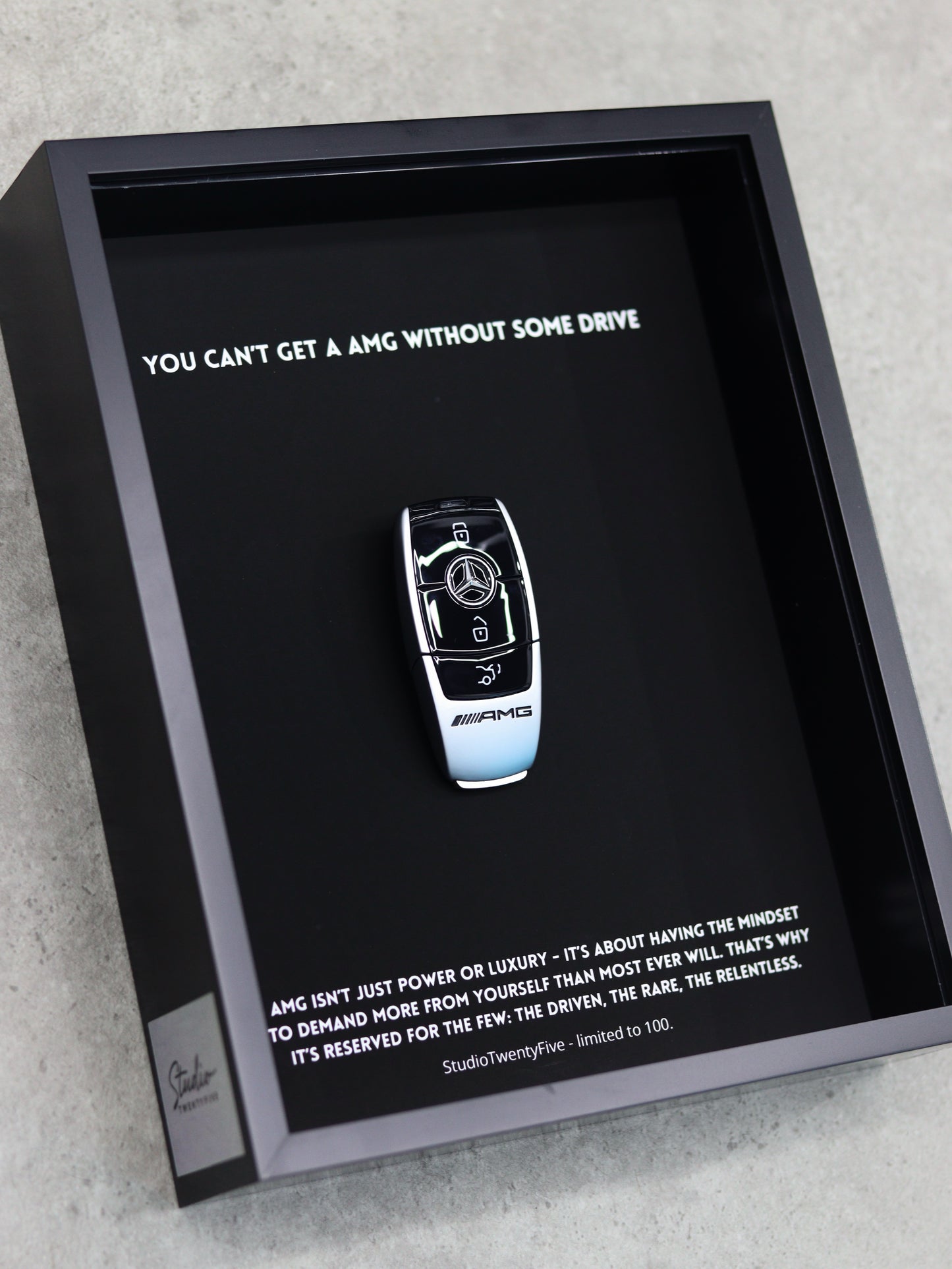 Close-up of AMG key art print showing performance badge and premium frame quality
